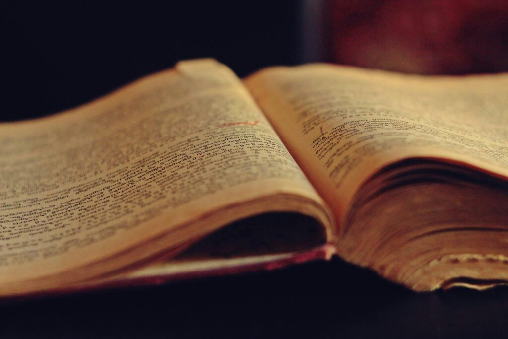 pexels-photo-69004-69004 A vintage open book displaying aged, yellowed pages with faded text.